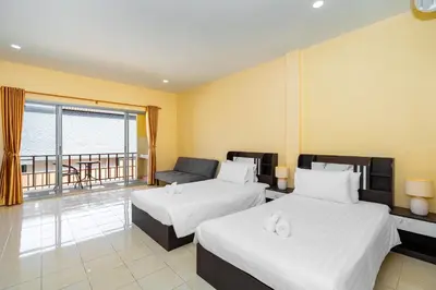 a hotel room with two beds and a balcony at Chernin Apartment Suites in Ban Saiyuan (1)