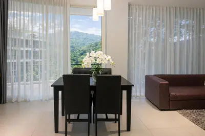 a dining room with a table and a couch at Zen Hilltop Nature Sanctuary Kamala Beach in Kamala Beach
