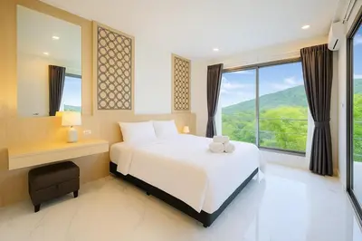 a bedroom with a white bed and a large window at Zen Hilltop Nature Sanctuary Kamala Beach in Kamala Beach
