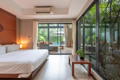 a bedroom with a bed and a large glass door at Tropic Escape @ Baan Wana Phuket in Thalang