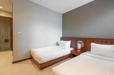 a hotel room with two beds and a bathroom at Tropic Escape @ Baan Wana Phuket in Thalang