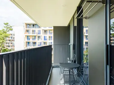 a balcony with a table and chairs and a building at Двухкомнатные апартаменты Laguna Skypark in Laguna Phuket