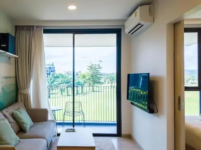 a living room with a couch and a sliding glass door at Двухкомнатные апартаменты Laguna Skypark in Laguna Phuket