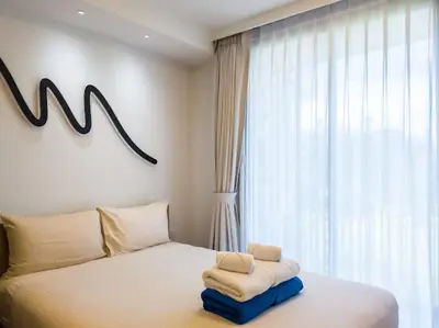 a bedroom with a bed with towels on it at Двухкомнатные апартаменты Laguna Skypark in Laguna Phuket