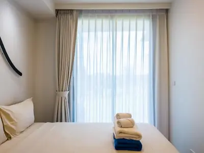 a bedroom with a bed with two towels on it at Двухкомнатные апартаменты Laguna Skypark in Laguna Phuket