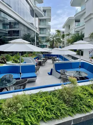 a patio with tables and chairs and umbrellas at Kora Beach 2Bdr 150 m to the Beach in Layan Beach
