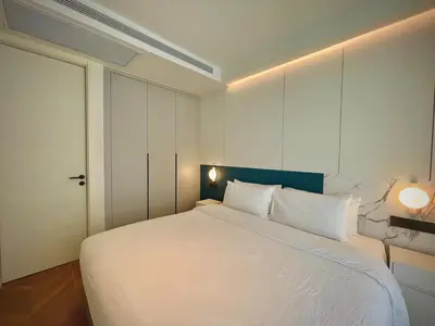 a bedroom with a large white bed with a blue headboard at Kora Beach 2Bdr 150 m to the Beach in Layan Beach