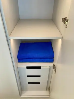 a white shelf with a blue cushion on it at Kora Beach 2Bdr 150 m to the Beach in Layan Beach