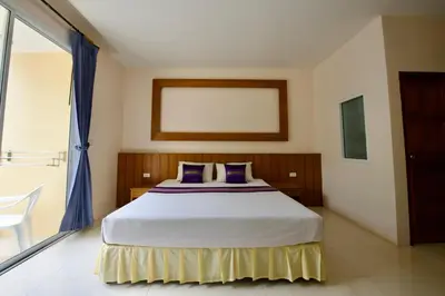 a bedroom with a bed and a large window at Ashiraya hostel in Kata Beach
