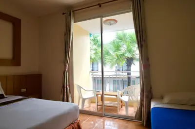 a bedroom with a bed and a view of a patio at Ashiraya hostel in Kata Beach
