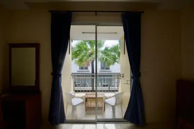 a room with a window with a table and chairs at Ashiraya hostel in Kata Beach