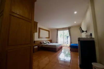 a room with a bedroom with a bed and a window at Ashiraya hostel in Kata Beach