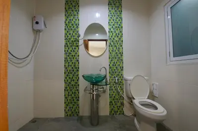 a bathroom with a toilet and a sink and a mirror at Ashiraya hostel in Kata Beach