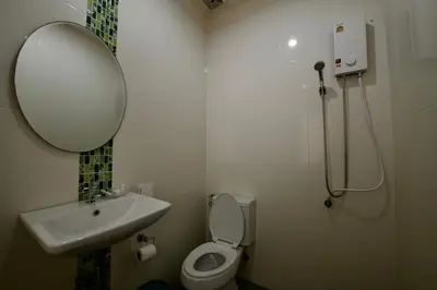 a bathroom with a sink and a toilet and a mirror at Ashiraya hostel in Kata Beach
