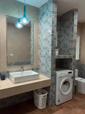 a bathroom with a sink and a washing machine at Roomy renovated Apartments in Phuket in Ban Sam Kong