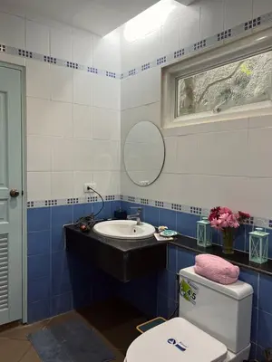 a bathroom with a toilet and a sink and a mirror at Roomy renovated Apartments in Phuket in Ban Sam Kong