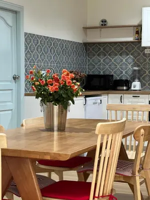 a kitchen with a wooden table with a bucket of flowers at Roomy renovated Apartments in Phuket in Ban Sam Kong