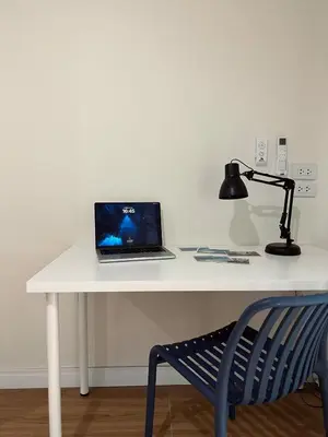 a laptop computer sitting on a white desk with a lamp at Roomy renovated Apartments in Phuket in Ban Sam Kong
