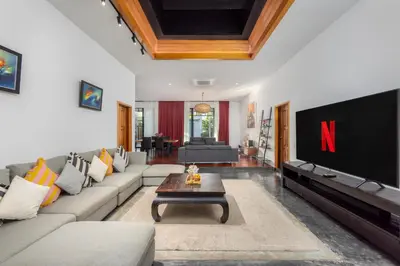 a living room with a large couch and a tv at Aroha Villa with Private Pool Near Nai Harn Beach in Rawai Beach