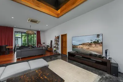 a living room with a flat screen tv on a wall at Aroha Villa with Private Pool Near Nai Harn Beach in Rawai Beach