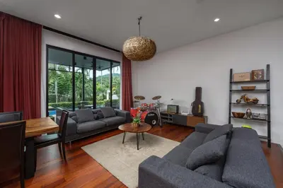 a living room with two couches and a table at Aroha Villa with Private Pool Near Nai Harn Beach in Rawai Beach