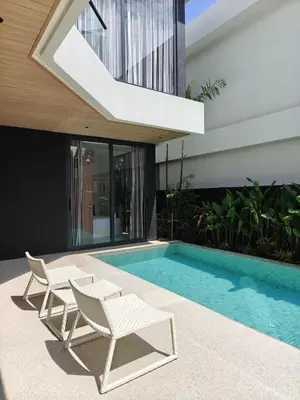 a swimming pool with two white chairs and a house at Aileen Layan Villa 2 Private Pool 4Bedroom in Phuket Town
