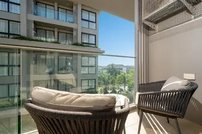 a balcony with two chairs and a large window at 2BR Apt 2510 Gem Resort near Bangtao Beach in Bang Tao Beach