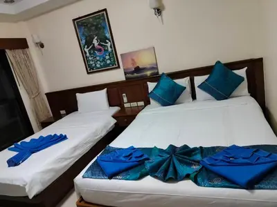 two beds in a room with blue pillows on them at Patong \u4e00\u5367\u4e09\u4eba\u95f4 in Patong Beach