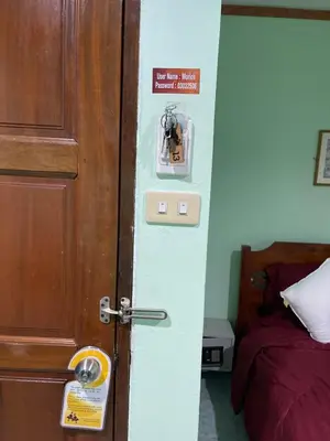 a room with a door with a lock and a bed at Rungtawan Hostel in Karon Beach