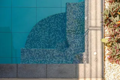 a blue tile wall with a reflection of a building at Tropical Rawai Beach Home Retreat with Pool & Gym in Rawai Beach