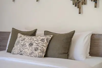 a bed with a bunch of pillows on it at Tropical Rawai Beach Home Retreat with Pool & Gym in Rawai Beach