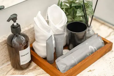 a wooden tray with a bottle of soap and towels at Tropical Rawai Beach Home Retreat with Pool & Gym in Rawai Beach