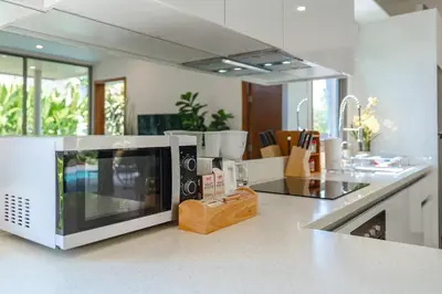 a microwave oven sitting on a counter in a kitchen at Tropical Rawai Beach Home Retreat with Pool & Gym in Rawai Beach