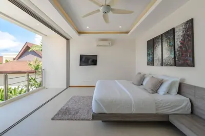 a bedroom with a bed and a balcony at Tropical Rawai Beach Home Retreat with Pool & Gym in Rawai Beach