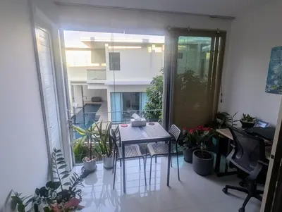 a balcony with a table and chairs and plants at Large 1 Bed Condo in Kamala Regent, Close to Beach in Kamala Beach
