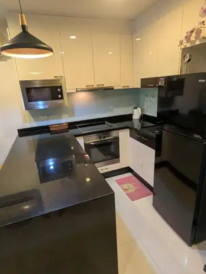 a kitchen with a black refrigerator and a microwave at Large 1 Bed Condo in Kamala Regent, Close to Beach in Kamala Beach