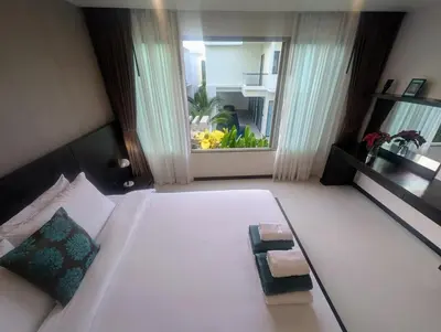 a large white bed in a room with a window at Large 1 Bed Condo in Kamala Regent, Close to Beach in Kamala Beach