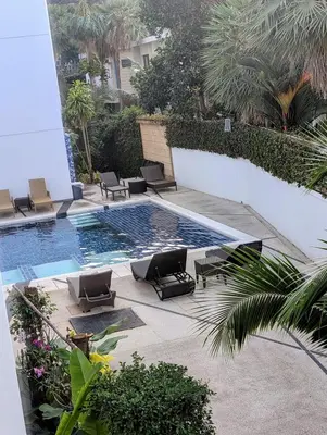 a swimming pool with lounge chairs next to a building at Large 1 Bed Condo in Kamala Regent, Close to Beach in Kamala Beach