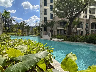 a swimming pool with blue water in front of buildings at 1BR Apartment near Bang-Tao Beach CapitalPro TLB-H206 in Bang Tao Beach