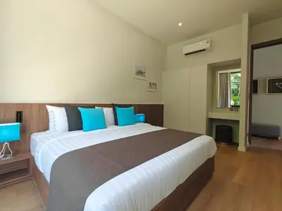 a bedroom with a large bed with blue pillows at Aileen Layan Villa 3 Private Pool 4 Bedroom in Phuket Town