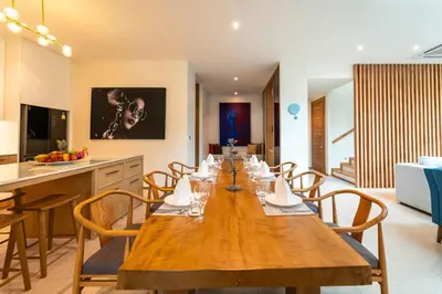 a dining room with a long wooden table and chairs at Luxury Teak 4BR Private Pool Villa in Bang Tao in Laguna Phuket