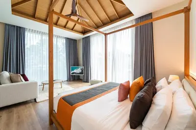 a bedroom with a large bed and a living room at Luxury Teak 4BR Private Pool Villa in Bang Tao in Laguna Phuket