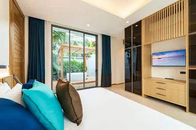 a bedroom with a large bed and a television at Luxury Teak 4BR Private Pool Villa in Bang Tao in Laguna Phuket