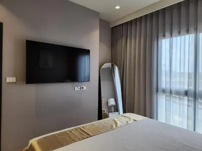 a bedroom with a bed and a flat screen tv at WEG Title Legendary in Bang Tao Beach