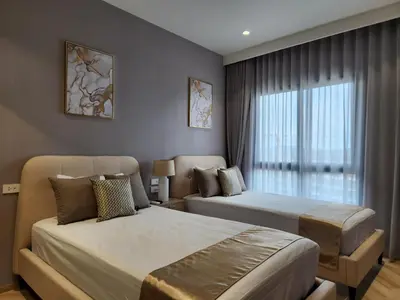 a hotel room with two beds and a window at WEG Title Legendary in Bang Tao Beach