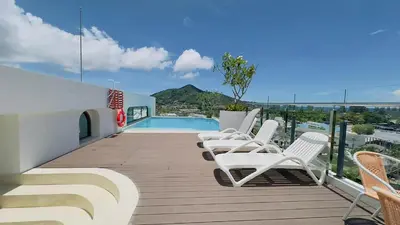 a deck with white chairs and a swimming pool at New apartment at Fantasea Kamala by Lofty in Kamala Beach