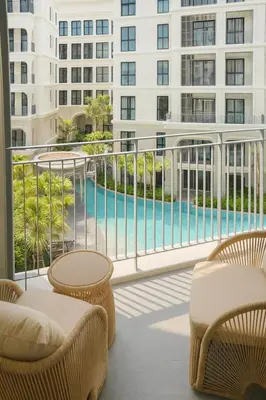 a balcony with chairs and a swimming pool on a building at Apartment at the brand new Title Legendary by Lofty in Bang Tao Beach
