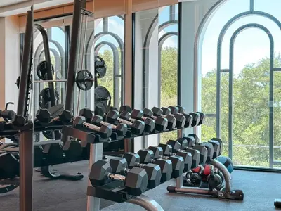 a gym with rows of exercise equipment and windows at Apartment at the brand new Title Legendary by Lofty in Bang Tao Beach