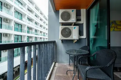 a balcony with a table and chairs and air conditioners at Modern Studio @ Kata Beach in Ban Karon