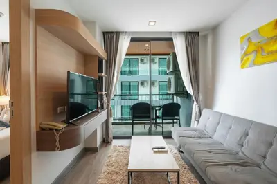 a living room with a couch and a tv at Modern Studio @ Kata Beach in Ban Karon